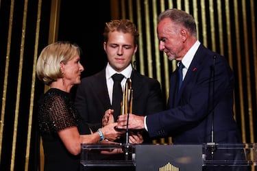 La viuda de Franz Beckenbauer, Heidi, el hijo de Franz Beckenbauer, Joel Beckenbauer, y el exjugador alemán Karl-Heinz Rummenigge suben al escenario durante un homenaje a Franz Beckenbauer durante la ceremonia de entrega del premio Balón de Oro.