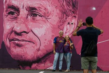 Fans take pictures beside the mural.