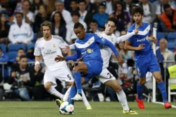 El defensa portugués del Almería UD Nélson Tomar (2i) protege el balón ante el centrocampista del Real Madrid Francisco Alarcón "Isco" (2d), durante el partido de la trigésima tercera jornada de liga de Primera División disputado esta noche en el estadio Santiago Bernabéu. 