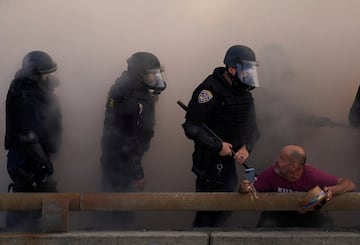 Agentes de policía observan a un manifestante durante una protesta contra las redadas federales de inmigración en el centro de Los Ángeles.