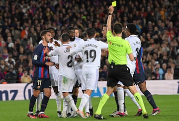 Ricardo De Burgos Bengoetxea, de espaldas, muestra una amarilla en el Clásico entre el Barcelona y el Madrid.