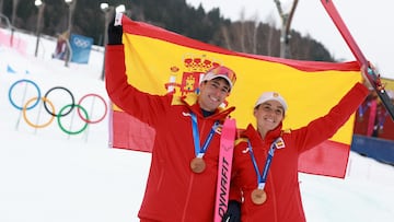 Milano Cortina 2026 Olympics - Ski Mountaineering - Mixed Relay Victory Ceremony - Stelvio Ski Centre, Bormio, Italy - February 21, 2026. Bronze medallist's Oriol Cardona Coll of Spain and Ana Alonso Rodriguez of Spain celebrate with their national flag after finishing third in the Ski Mountaineering Mixed Relay REUTERS/Gintare Karpaviciute