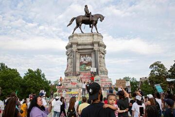 People gather around the Robert E. Lee statue on Monument Avenue in Richmond, Virginia.