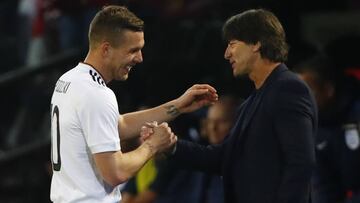 Lukas Podolski shakes hands with coach Joachim Low as he walks off to be substituted