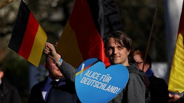 FILE PHOTO: An AfD supporter holds a placard as activists protest against an Alternative for Germany party (AfD) election campaign rally in Neu-Isenburg, Germany, February 1, 2025. REUTERS/Kai Pfaffenbach/File Photo