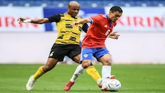 Ghana's Andre Ayew (L) and Chile's Nayel Mehssatou compete for the ball during the Kirin Cup football match between Chile and Ghana at Panasonic stadium in Suita, Osaka prefecture on June 14, 2022. (Photo by CHARLY TRIBALLEAU / AFP)