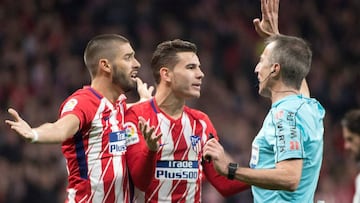 Los jugadores del Atlético protestan al árbitro.