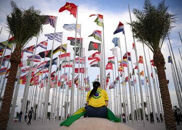 Una seguidora brasileña espera debajo de las banderas de las selecciones participantes del Mundial de Qatar 2022.