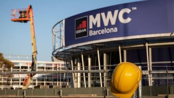 Un casco de obra amarillo colgado en una de las vallas que cierran el recinto del Mobile World Congress (MWC) durante el desmantelamiento de los stands tras la cancelaci&oacute;n de la feria por la crisis del coronavirus y las anulaciones de empresas, en 