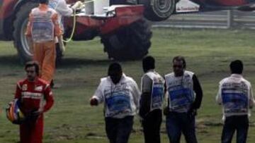 Alonso se retira mientras la grúa levanta su Ferrari.