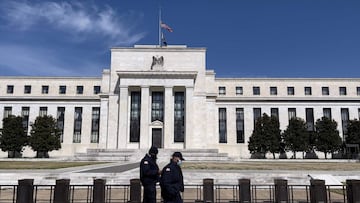 In this file photo taken on March 19, 2021, people walk past the Federal Reserve building in Washington, DC.