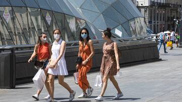 Imagen de un grupo de mujeres que caminan por la Puerta del Sol de Madrid portando, tres de las cuatro chicas, mascarillas.