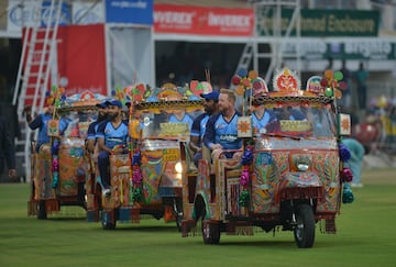 Jugadores del International World XI entran al al campo en autorickshaws, como se les conoce a estos vehículos, en la entrada principal del Gaddafi Cricket Stadium en Lahore, Pakistan.