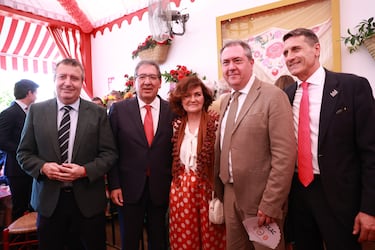 El presidente de la Fundación La Caixa , Antonio Pulido (2i) junto a la ex ministra, Carmen Calvo, (c) el presidente de la Diputación de Sevilla, Javier Fernández (i) el delegado del gobierno en Andalucía, Pedro Fernández (d) y el secretario general del PSOE A, Juan Espadas (2d) coinciden en la caseta de la fundación en el Real.