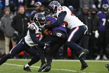 Houston Texans cornerback D'Angelo Ross and linebacker Neville Hewitt tackle Baltimore Ravens wide receiver Devin Duvernay.