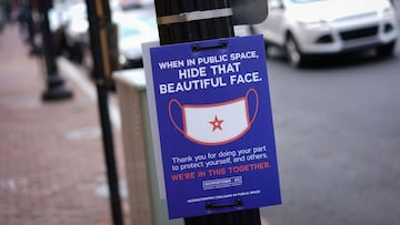 A sign on a lamppost requests people to wear face masks in the Georgetown district of Washington, DC on June 22, 2020. - Washington, DC begins Phase Two of reopening on June 22, 2020 as additional restrictions have been lifted on restaurants, nonessential