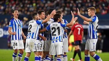 Real Sociedad's Spanish midfielder Mikel Merino (C) celebrates with teammates after scoring his team's first goal during the Spanish league football match between CA Osasuna and Real Sociedad at El Sadar stadium in Pamplona on November 7, 2021.