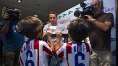 &Iacute;DOLO. Koke se dispone a firmar a dos ni&ntilde;os que llevan puesta la camiseta del Atl&eacute;tico y el nombre del futbolista a la espalda.
 