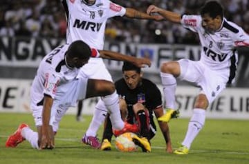 Juan Delgado disputa el balón con Jó y Leandro Donizete , de Atlético Mineiro.