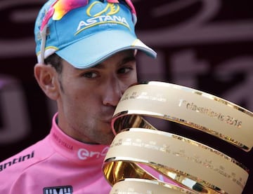 Vincenzo Nibali posa con la maglia rosa en el podio de Turín y besa el trofeo de ganador del Giro de Italia.
