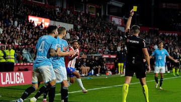 Spanish referee Isidoro Diaz de Mera gives yellow card to Celta Vigo's Spanish defender #04 Unai Nunez (L) and Girona's Uruguayan forward #07 Cristhian Stuani (C) during the Spanish league football match between Girona FC and RC Celta de Vigo at the Montilivi stadium in Girona on October 27, 2023. (Photo by Pau BARRENA / AFP)