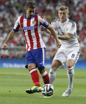 El centrocampista alemán del Real Madrid Toni Kroos lucha por el balón con el centrocampista del Atlético de Madrid Gabi Fernández.