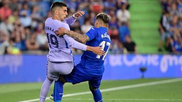 Barcelona's Spanish forward Ferran Torres (L) fights for the ball with Getafe's Uruguayan defender Mathias Olivera during the Spanish league football match between Getafe CF and FC Barcelona at the Col. Alfonso Perez stadium in Getafe on May 15,