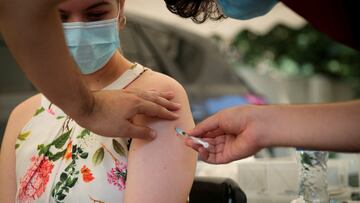 FILE PHOTO: A healthcare worker administers the coronavirus disease (COVID-19) vaccine to a woman, amidst the spread of the SARS-CoV-2 variant Omicron in Johannesburg, South Africa, December 04, 2021. Picture taken December 04, 2021. REUTERS/ Sumaya Hisham/File Photo