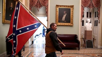 FILE PHOTO: A supporter of President Donald Trump carries a Confederate battle flag on the second floor of the U.S. Capitol near the entrance to the Senate after breaching security defenses, in Washington, U.S., January 6, 2021.         REUTERS/Mike Theil