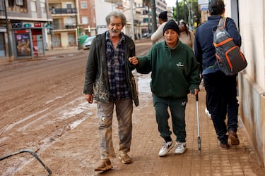 La gente camina por una calle cubierta de barro, tras las fuertes lluvias del pasado 29 de octubre.