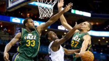 Kemba Walker trata de anotar ante la defensa de Trevor Booker (33) y Rudy Gobert (27).