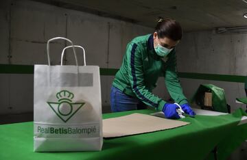 Los voluntarios trabajan en el aparcamiento del estadio Benito Villamarín preparando el material que luego distribuyen a los más necesitados, como es el caso del hogar de ancianos de Santa Justa. 