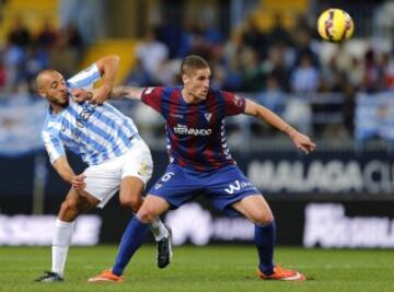 El defensa del Eibar Raúl Albentosa (d) lucha por el balón con el marroquí Nordin Amrabat, del Málaga, durante el partido de Liga en Primera División que disputan esta noche en el estadio de La Rosaleda. 