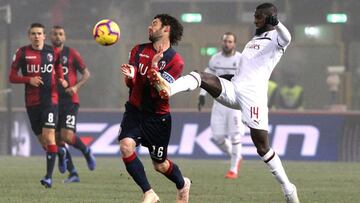 El jugador de Bologna Andrea Poli disputa el bal&oacute;n con Tiemoue Bakayoko, del Milan