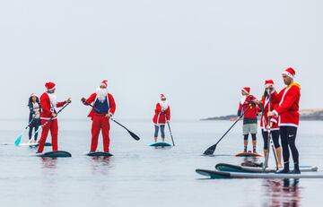 Un grupo de personas practica paddle-surf con una indumentaria muy singular: vestimentas de Papá Noel. Esperemos que entre tanto impostor no se encuentre el verdadero Papá Noel, que demasiado tiene ya con el elevado volumen de trabajo que soporta en estas fechas navideñas.