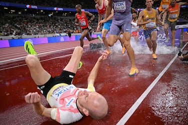 El atleta belga Tim Van De Velde (izq.) se accidenta mientras compite en las eliminatorias de los 3000 m con obstáculos masculinos durante el Campeonato Mundial de Atletismo en Tokio.