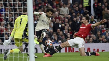 Liverpool's Mohamed Salah attempts a shot at goal as Manchester United's Harry Maguire, right, tries to block him during the English Premier League soccer match between Manchester United and Liverpool at Old Trafford in Manchester, England, Sund