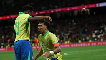 Brazil's midfielder #08 Lucas Paqueta celebrates with Brazil's forward #21 Endrick scoring his team's third goal during the international friendly football match between Spain and Brazil at the Santiago Bernabeu stadium in Madrid on March 26, 2024. Spain arranged a friendly against Brazil at the Santiago Bernabeu under the slogan "One Skin" to help combat racism. (Photo by Pierre-Philippe MARCOU / AFP)