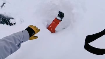 Mano intentando agarrar otra mano que emerge entre la nieve de un esquiador enterrado por una avalancha en los Alpes, el 10 de enero del 2026
