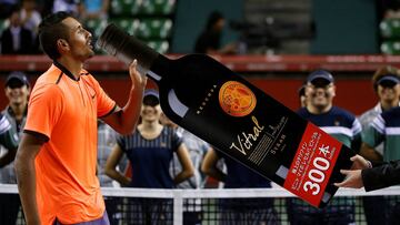 Tennis - Japan Open men's Singles Final Match - Ariake Coliseum, Tokyo, Japan - 09/10/16. Nick Kyrgios of Australia pretends to drink a cutout of a wine bottle which was given to him as an additional prize. REUTERS/Kim Kyung-Hoon