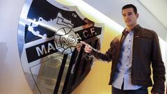 Luis Hern&aacute;ndez se&ntilde;alando el escudo del M&aacute;laga tras haber firmado su contrato.