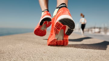 Close up runner feet. Man runner legs and shoes in action on road outdoors at road near sea. Male athlete model.