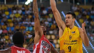 Nico Brussino, del Dreamland Gran Canaria, lanza ante Nike Sibande, del Básquet Girona.