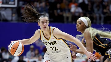 Caitlin Clark #22 of the Indiana Fever dribbles against DiJonai Carrington #21 of the Connecticut Sun.