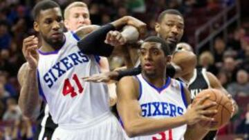 Hollis Thompson pasa al lado de su compañero Thomas Robinson mientras Cory Jefferson, de los Nets, trata de impedírselo.