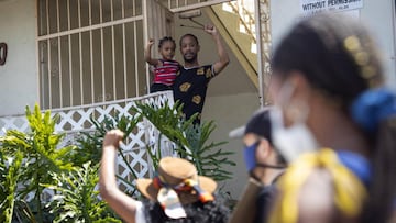 People march past a young boy and his father on Martin Luther King Jr. Blvd during a protest on the Juneteenth Holiday in Los Angeles, California, USA.