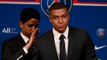 Paris Saint-Germain's CEO Nasser Al-Khelaifi (L) and French forward Kylian Mbappe (R) pose with a jersey at the end of a press conference at the Parc des Princes stadium in Paris on May 23, 2022, two days after the club won the Ligue 1 title for a record-equalling tenth time and its superstar striker Mbappe chose to sign a new contract until 2025 at PSG rather than join Real Madrid. (Photo by FRANCK FIFE / AFP)