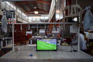 Mientras trabajan, los seguidores de la selección colombiana no se pierden ni un minuto del partido.