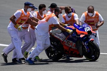 Los operarios retiran la moto de Miguel Oliveira tras el accidente. 
