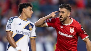Imagen de Paulinho, con uniforme rojo del Toluca, con el dedo índice en su cabeza.